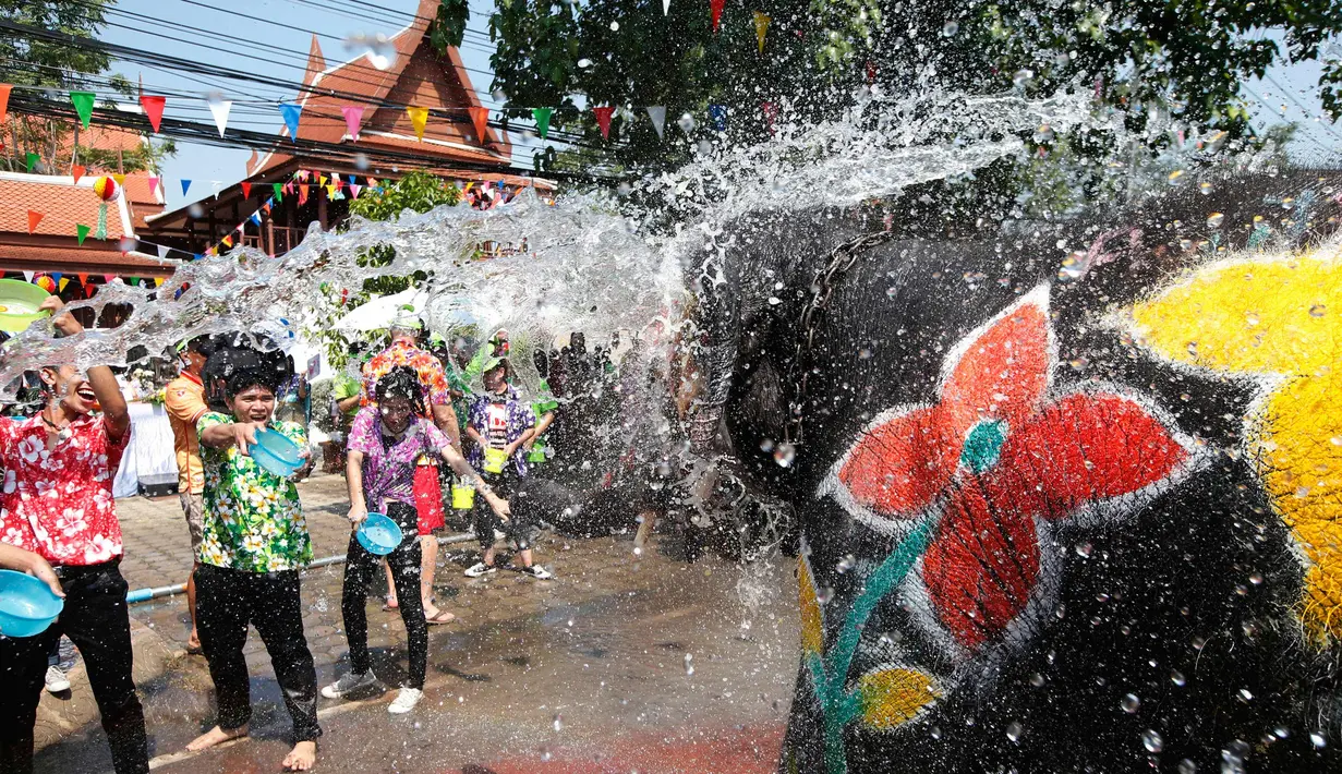 Warga dan seekor gajah saling menyiramkan air dalam perayaan festival air Songkran di provinsi Ayutthaya, utara Bangkok, Thailand, (11/4). Selama perayaan Songkran, warga melakukan perang air di jalanan dan di tempat umum. (AP Photo/Sakchai Lalit)