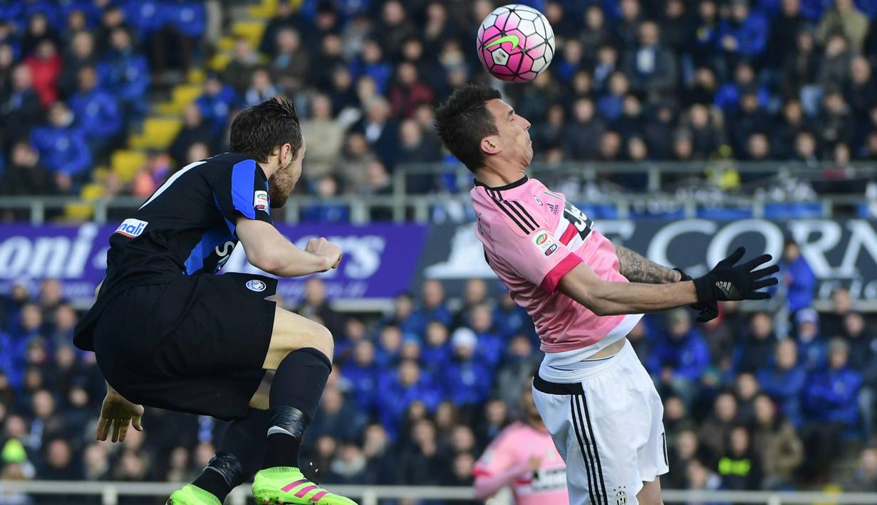 Pemain Juventus, Mario Mandzukic (kanan) menyundul bola saat berduel denan pemain Atalanta, Luca Cigarini pada lanjutan Serie A 2015-2016  di Stadion Atleti Azzurri d'Italia, Minggu (6/3/2016) malam WIB. (AFP/Olivier Morin)