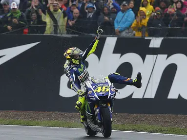Pebalap Movistar Yamaha, Valentino Rossi, merajai lintasan basah dengan memenangi MotoGP Inggris, Minggu (30/8/2015). Rossi finis pertama di Sirkuit Silverstone, Inggris. (Reuters/Darren Staples)