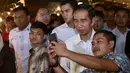 Seorang pria berswafoto dengan Presiden Joko Widodo (Jokowi) saat blusukan ke Pasar Bogor di Jalan Roda, Kota Bogor, Selasa (30/10) malam. Jokowi berinteraksi dengan para pedagang tentang harga bahan pokok. (Liputan6.com/HO/Biro Pers Setpres)