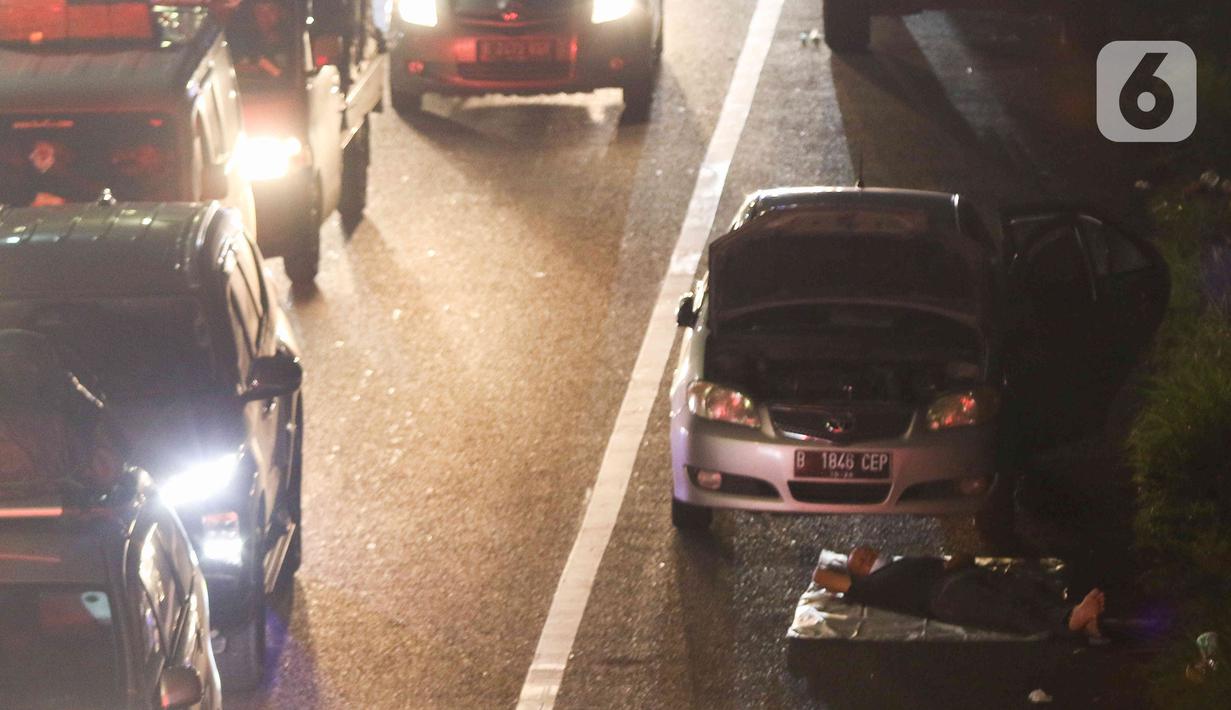 <p>Seorang pemudik terlihat beristirahat di depan mobilnya yang berhenti di tepian ruas jalan tol Cikopo-Palimanan, Jawa Barat, Kamis (28/4/2022). Ruas jalan tol yang mengalami peningkatan menyebabkan sebagian pemudik memilih untuk beristirahat di tepi jalan tol meski hal tersebut melanggar pertaturan yang berlaku. (Liputan6.com/Herman Zakharia)</p>