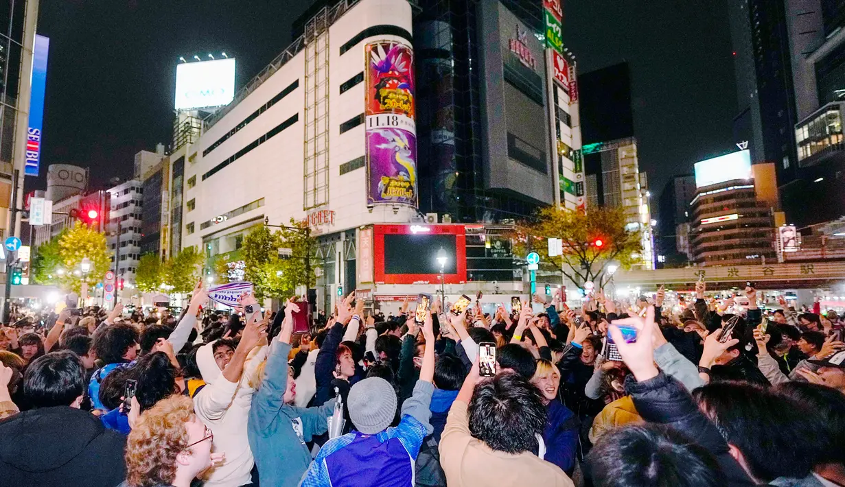 Orang-orang merayakan kemenangan timnas Jepang saat melawan Jerman di Piala Dunia Qatar 2022 di persimpangan Shibuya, Tokyo, Jepang, Kamis (24/11/2022). Jepang membuka sejarah baru untuk pertama kalinya karena mampu mengalahkan Jerman yang menyandang status empat kali juara Piala Dunia. (Kyodo News via AP)