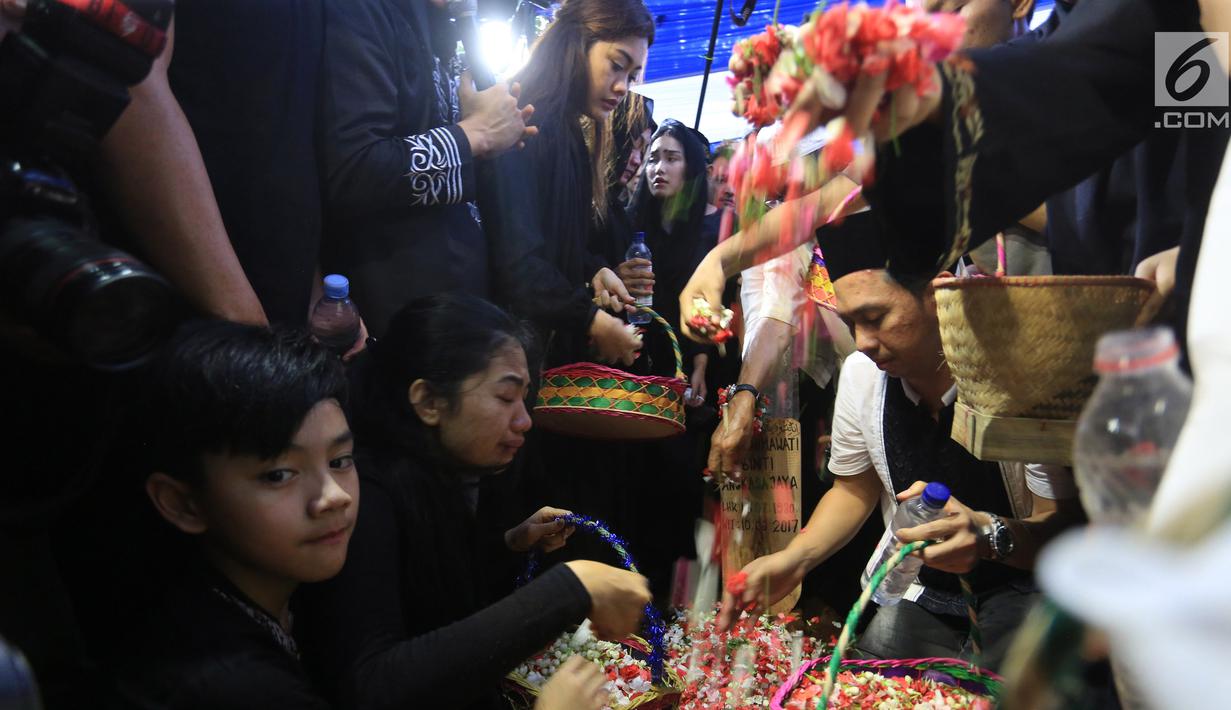 Sejumlah keluarga dan kerabat menaburkan bunga  di atas makam Julia Perez di Taman Pemakaman Umum Pondok Ranggon, Cijantung, Jakarta Timur, Sabtu (10/6). Jupe menghembuskan napas terakhir di RSCM, pada Sabtu 10 Juni 2017. (Liputan6.com/Herman Zakharia)