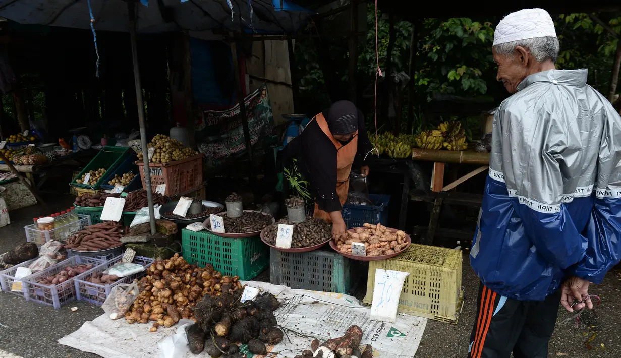 Seorang wanita muslim melayani pembeli di pinggir jalan di Narathiwat, provinsi selatan Thailand (19/12). Narathiwat adalah tiga provinsi Thailand yang mempunyai jumlah umat Muslim yang besar. (AFP Photo/Lillian Suwanrumpha)