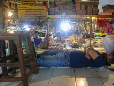 Pedagang tertidur diantara kios yang sepi pembeli di Pasar Senen, Jakarta, Selasa, (1/10/2024). (merdeka.com/Arie Basuki)