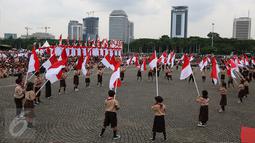 Sejumlah siswa membawa bendera merah putih saat acara Nusantara Bersatu di Monas, Jakarta, Rabu (30/11). Sekitar 40.000 orang hadir dalam acara tersebut, dengan mengenakan pita merah putih yang diikatkan di kepala. (Liputan6.com/Johan Tallo)