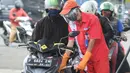 Petugas dengan sarung tangan, masker dan pelindung wajah melayani pembeli BBM di SPBU kawasan Cilendek, Bogor, Selasa (5/5/2020). Mencegah penularan Covid-19, sejumlah perusahaan memberikan pelindung diri kepada pegawai, terlebih yang berhubungan langsung dengan pelanggan. (merdeka.com/Arie Basuki)