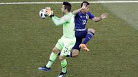Kiper Polandia Lukasz Fabianski menangkap bola dengan striker Jepang Yoshinori Muto berusaha mengejar pada partai Grup H Piala Dunia 2018 di Volgograd Arena, Kamis (28/6/2018). (AP Photo/Themba Hadebe)