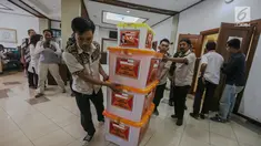 Petugas membawa berkas milik partai politik calon peserta pemilu 2019 di kantor KPU, Jakarta, Selasa (17/10). KPU memusatkan proses penelitian administrasi berkas parpol 2019 menuju Hotel Mercure.  (Liputan6.com/Faizal Fanani)