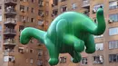 Balon raksaksa berbentuk Dino Saurus ikut meramaikan Parade Thanksgiving Day di New York City (26/11/2015). Beragam balon raksaksa yang dibuat seperti tokoh animasi menjadi suguhan utama dalam perayaan tersebut. (AFP Photo/Timothy A. Clary)