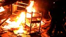 Seorang warga membakar barang-barang yang tidak diinginkan saat mengikuti tradisi malam San Juan's (Saint John) di Gijon, Spanyol, (24/6/). Malam San Juan juga dilakukan dengan berenang saat musim panas tiba. (REUTERS/Vincent West)