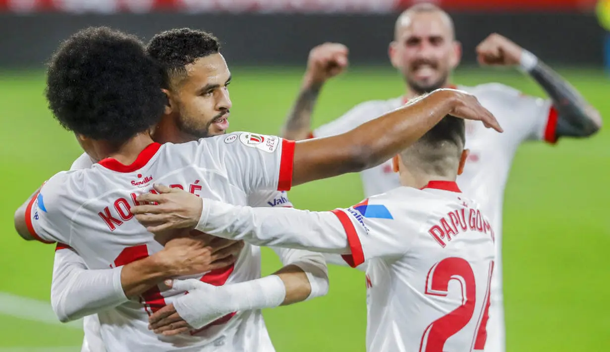 Para pemain Sevilla merayakan gol yang dicetak oleh Jules Kounde ke gawang Barcelona pada laga leg pertama semifinal Copa del Rey di Estadio Ramon Sanchez Pizjuan, Kamis (11/2/2021). Barcelona tumbang dengan skor 2-0. (AP/Angel Fernandez)