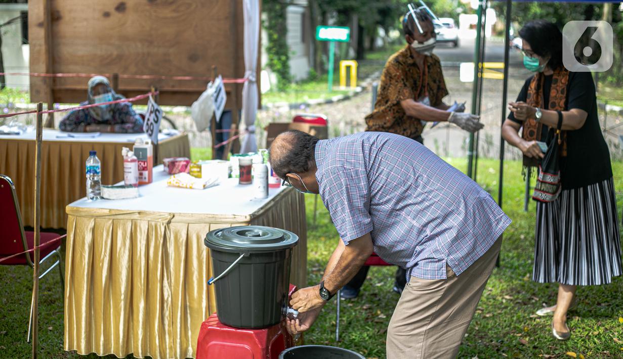 Warga mencuci tangan sebelum memberikan hak suaranya di Tempat Pemungutan Suara (TPS) 69 Pisangan, Ciputat, Tangerang Selatan, Rabu (9/12/2020). Protokol kesehatan dipraktikkan cukup ketat di TPS di Pilkada Tangerang Selatan (Tangsel) untuk menghindari penularan COVID-19 (Liputan6.com/Faizal Fanani)