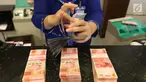 Petugas tengah menghitung uang rupiah di Bank BUMN, Jakarta, Selasa (17/4). Mengacu data Bloomberg, rupiah siang ini pukul 12.00 WIB di pasar spot exchange sebesar Rp 13.775 per dolar AS atau menguat 4,7 poin. (Liputan6.com/Angga Yuniar)