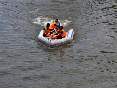 Petugas UPK Badan Air Provinsi DKI Jakarta melakukan ujicoba ketahanan dan kesimbangan perahu yang terbuat dari botol plastik bekas di aliran Kanal Banjir Timur (KBT), Jakarta, Selasa (5/3/2024). (merdeka.com/Imam Buhori)