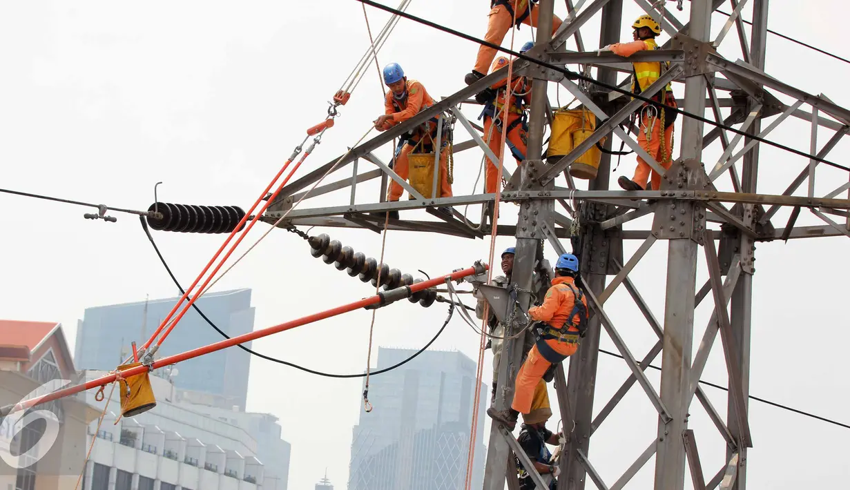 Petugas PLN memperbaiki Menara Sutet di Jalan Asia Afrika, Jakarta, Rabu (12/8/2015). Pekerjaan tersebut mengandung resiko besar karena jaringan listrik masih dipelihara tanpa dipadamkan. (Liputan6.com/Helmi Afandi)