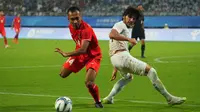Pemain Timnas Indonesia U-24, Robi Darwis, berhasil melewati penjagaan pemain Timnas Uzbekistan U-24 dalam pertandingan 16 besar Asian Games 2022 yang berlangsung di Stadion Shangcheng Sports Centre, Kamis (28/9/2023). (Bola.com/NOC/Naif Al'as)