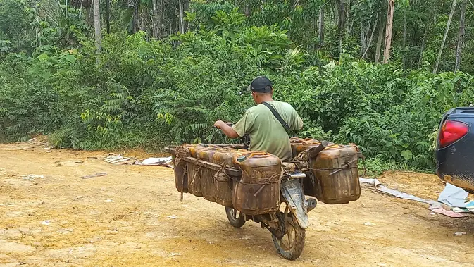 <p>Seorang pekerja sedang melangsir minyak ilegal di kawasan Hutan Harapan KM 52, perbatasan Jambi-Sumsel, Senin (4/11/2024). Aktivitas pengeboran minyak ilegal ini telah berdampak menghancurkan sekitar 380 hektare kawasan hutan restorasi. (Liputan6.com/Gresi Plasmanto)</p>