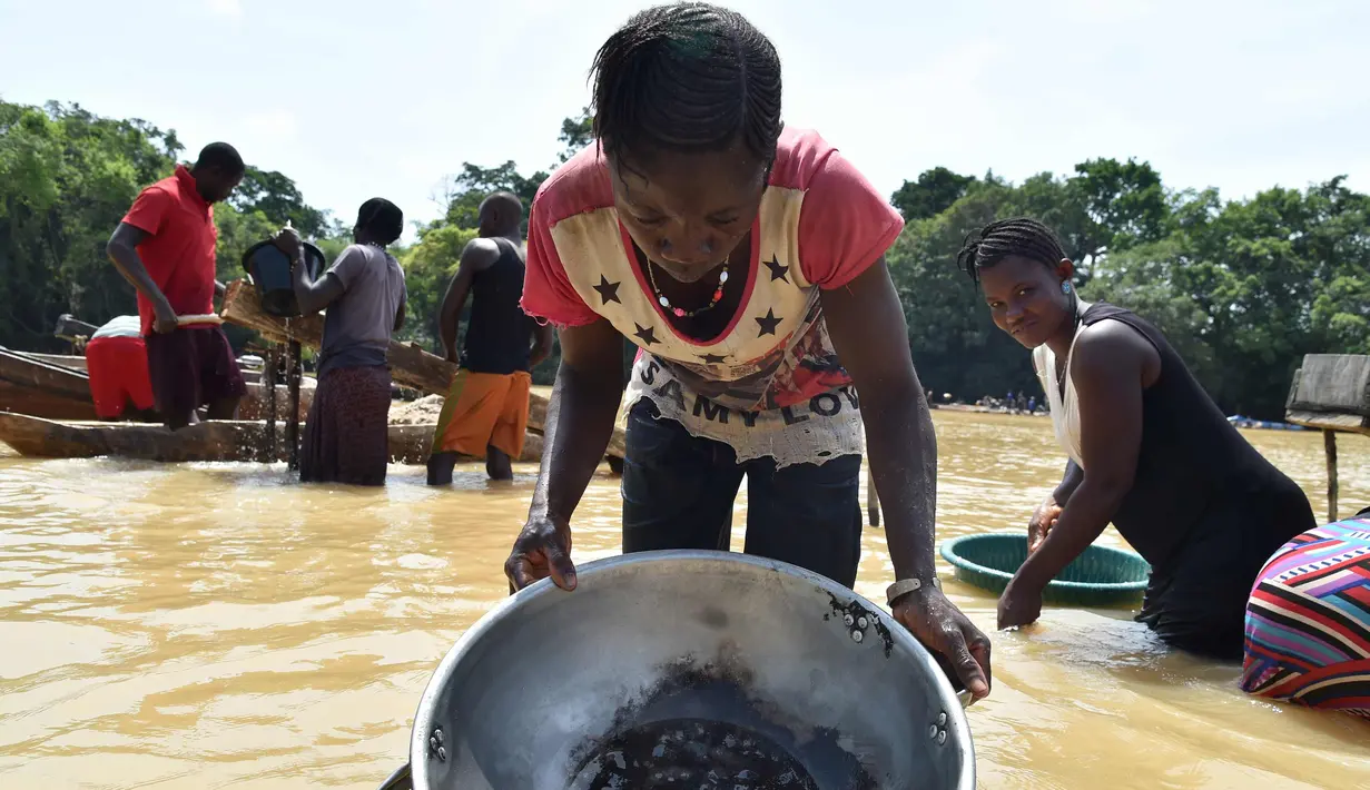 Seorang penembang emas wanita menyaring kerikil dan memisahkan bintik-bintik emas dari lumpur di sungai Pampana di dekat Mekeni, sebelah utara Sierra Leone (5/3). (AFP Photo/Issouf Sanogo)
