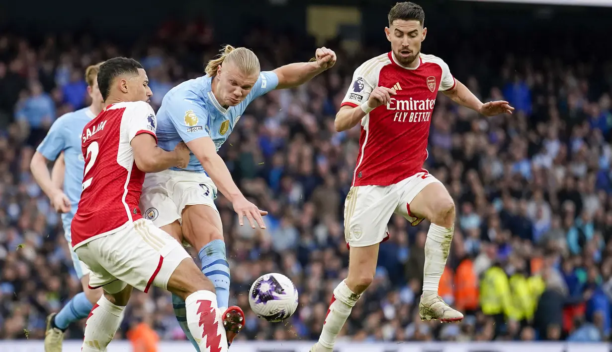 Bek Arsenal, William Saliba (kiri) berusaha memblok tendangan striker Manchester City, Erling Haaland pada laga pekan ke-30 Premier League 2023/2024 di Etihad Stadium, Manchester, Minggu (31/3/2024). (AP Photo/Dave Thompson)