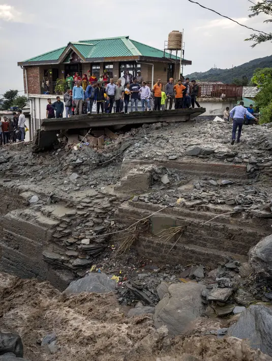 Orang-orang menyaksikan kerusakan yang disebabkan oleh tanah longsor setelah hujan deras di Khaniyara, dekat Dharmsala, India (2/9/2022). Tidak ada korban jiwa yang dilaporkan akibat musibah tersebut. (AP Photo/Ashwini Bhatia)