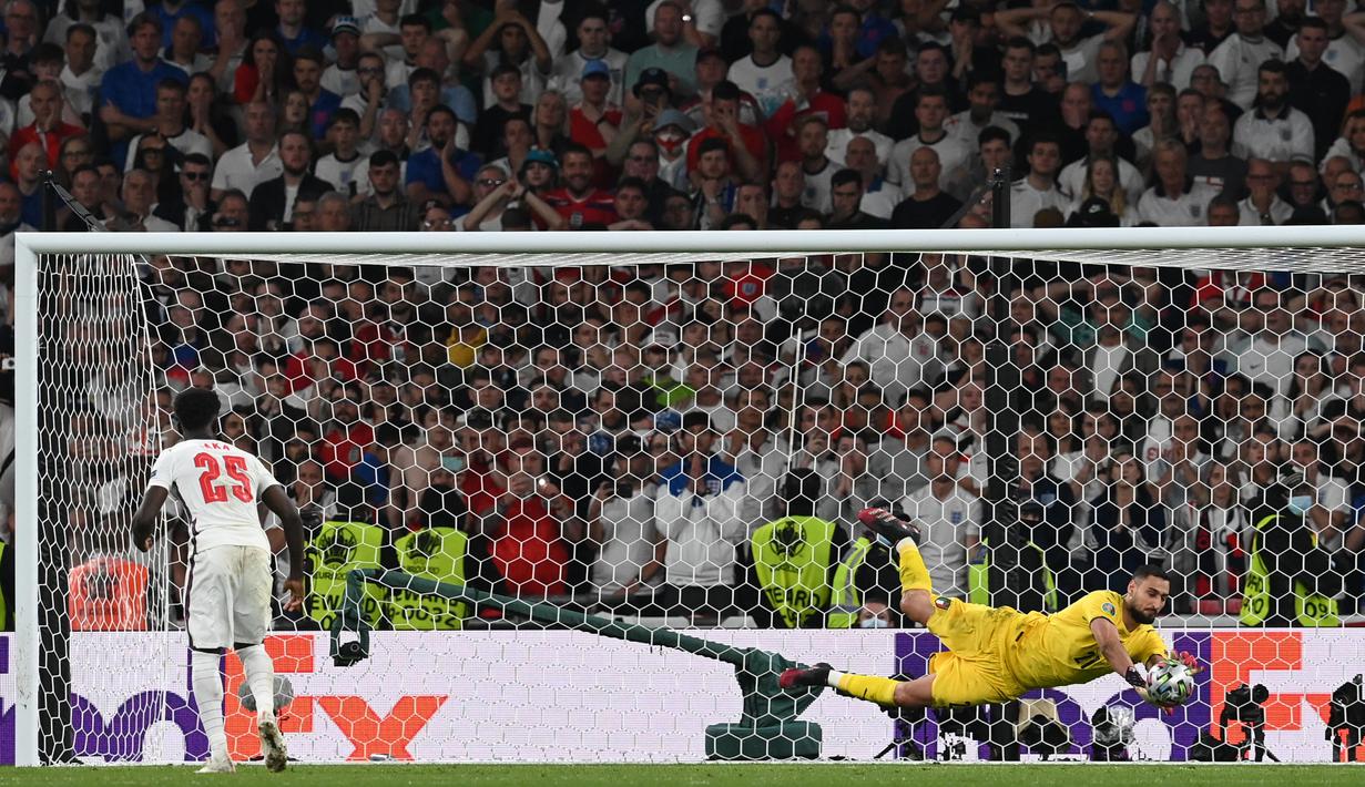 Penjaga gawang Italia Gianluigi Donnarumma menggagalkan penalti yang dilakukan gelandang Inggris Bukayo Saka dalam adu penalti pada pertandingan final Piala Euro 2020. Italia berhasil meraih trofi Piala Euro 2020. (AFP/Pool/Paul Ellis)