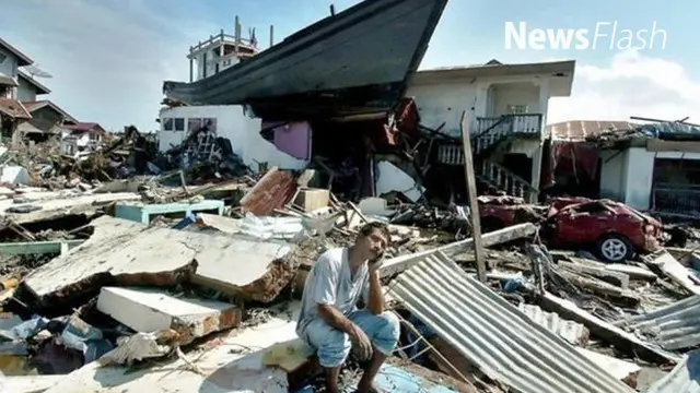 Hari Minggu 12 tahun silam itu, Saiful Yusri (62) bersama istri dan anaknya sedang berada di rumah saat gempa tiba-tiba menguncang bumi. Saat itu warga berhamburan keluar rumah.