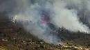 Asap mengepul dari gunung berapi Cumbre Viegja di pulau La Palma di Kepulauan Canaria, Spanyol, Minggu (19/9/2021). Cumbre Vieja yang terakhir kali erupsi 50 tahun lalu berada di punggung bukit di selatan Pulau La Palma yang dihuni sekitar 80 ribu orang. (AP Photo/Jonathan Rodriguez)