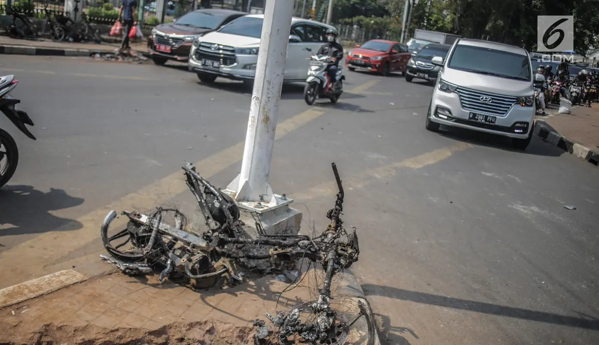 Bangkai sepeda motor usai dibakar massa aksi tergeletak di bawah jembatan layang Slipi, Jakarta, Kamis (26/9/2019). Aksi menolak revisi UU KPK, revisi UU KUHP dan sejumlah revisi UU lainnya berjalan anarkis di sekitar Gedung DPR pada Rabu 25 September 2019. (Liputan6.com/Faizal Fanani)