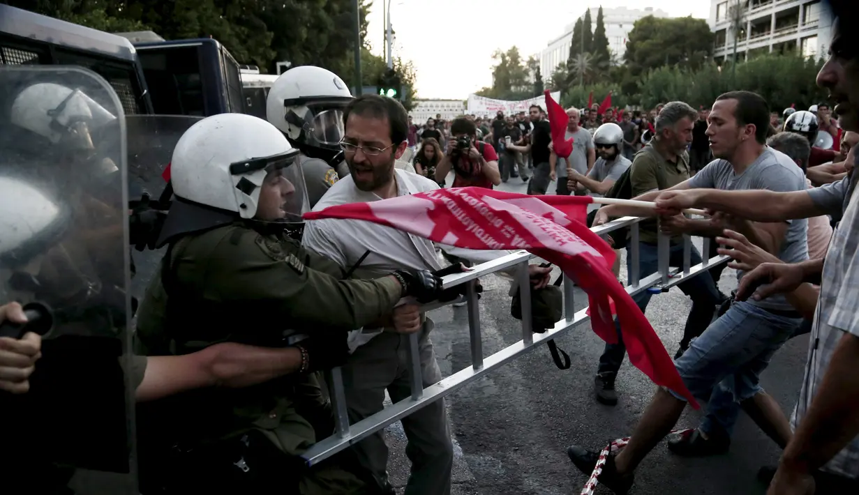 Pengunjuk rasa anti-Eropa berebut atribut dengan petugas kepolisian di Athena, Yunani, (2/7/2015). PM Alexis Tsipras mengatakan tutupnya bank tidak akan lama setelah adanya kontrak baru dengan kreditur setelah referendum. (REUTERS/Panayiotis Tzamaros)
