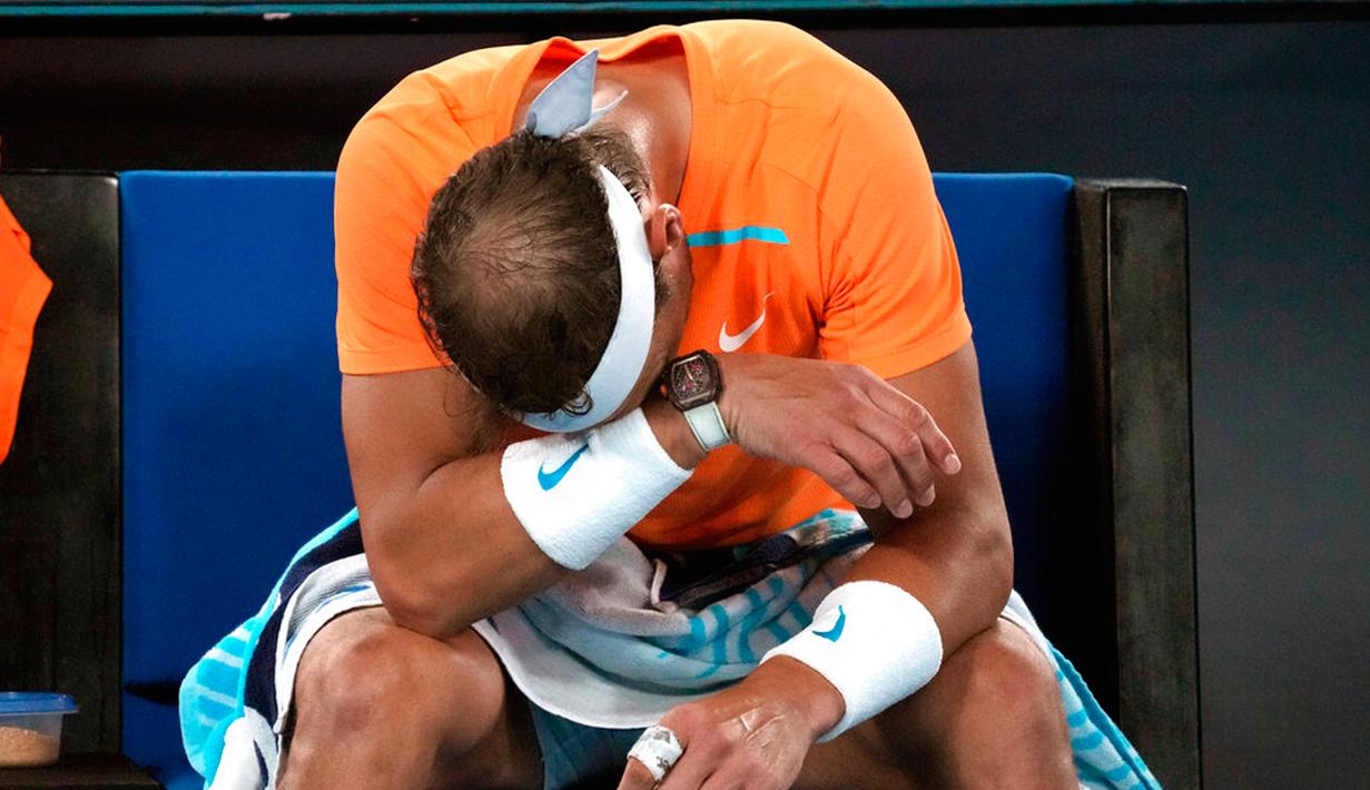 Reaksi petenis Spanyol Rafael Nadal setelah kalah dari petenis Amerika Serikat Mackenzie McDonald pada pertandingan putaran kedua kejuaraan tenis Australian Open di Melbourne, Australia, Rabu (18/1/2023). Rafael Nadal harus tersingkir dari Australian Open 2023 setelah ia mengalami cedera dan kemudian takluk 4-6, 4-6, 5-7 dari petenis Amerika Serikat MacKenzie McDonald. (AP Photo/Dita Alangkara)