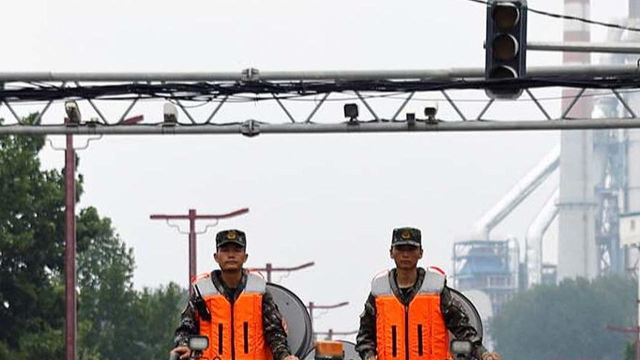 Pasukan tentara China terlihat membelah banjir dengan kendaraan militer serbaguna.