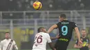 Penyerang Inter Milan, Edin Dzeko berebut bola udara dengan pemain Torino, Koffi Djidji pada pertandingan Liga Serie A Italia di Stadion San Siro, di Milan, Italia, Kamis (23/12/2021). Hasil ini membuat Inter tetap berada di puncak klasemen dengan koleksi 44 poin. (AP Photo/Luca Bruno)