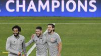 Pemain Liverpool, Mohamed Salah, Alberto Moreno dan Adam Lallana, tertawa saat sesi latihan jelang laga Liga Champions di Stadion Ramon Sanchez Pizjuan, Senin (20/17/2018). Liverpool akan berhadapan dengan Sevilla.  (AFP/Cristina Quicler)