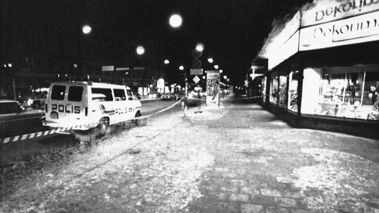 Mobil polisi berjaga di lokasi pembunuhan Perdana Menteri Swedia Olof Palme di persimpangan Tunnelgatan–Sveavagen, Stockholm, 1 Maret 1986. Noda gelap di trotoar adalah darah korban.