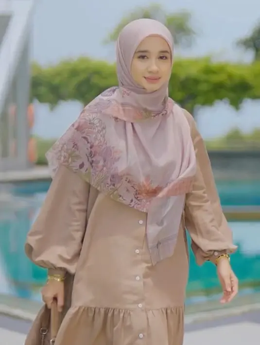 Ketika mengenakan maxi dress polos, tanpa aksesori berlebih, Bella memadukannya dengan hijab segi empat syar’i bermotif untuk membuat tampilannya lebih hidup. [@lbylcb].
