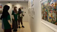 Pengunjung mengamati karya lukis yang bertajuk 'Membangun Harmoni' di Museum Basoeki Abdullah, Jakarta, Sabtu (18/12/2021). Pameran tersebut dibisa disaksikan dari 19 Desember 2021 hingga Januari 2022. (Liputan6.com/Herman Zakharia)