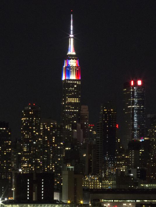 Lampu warna bendera juara Piala Dunia 2018, Prancis, mewarnai gedung pencakar langit Empire State di New York, Minggu (15/7). Meski gagal lolos Piala Dunia 2018, Amerika Serikat memiliki cara tersendiri memeriahkan ajang itu. (AFP PHOTO / KENA BETANCUR)