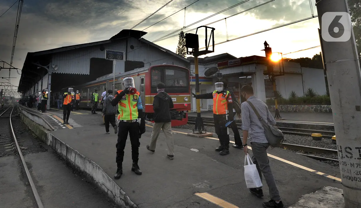 Petugas stasiun memandu penumpang KRL Commuterline di Stasiun Bogor, Jawa Barat, Selasa (9/6/2020) pagi. Puluhan polisi, TNI, Satpol PP, dan petugas stasiun diterjunkan untuk memandu penumpang mengantisipasi antrean panjang seperti kemarin. (merdeka.com/Arie Basuki)