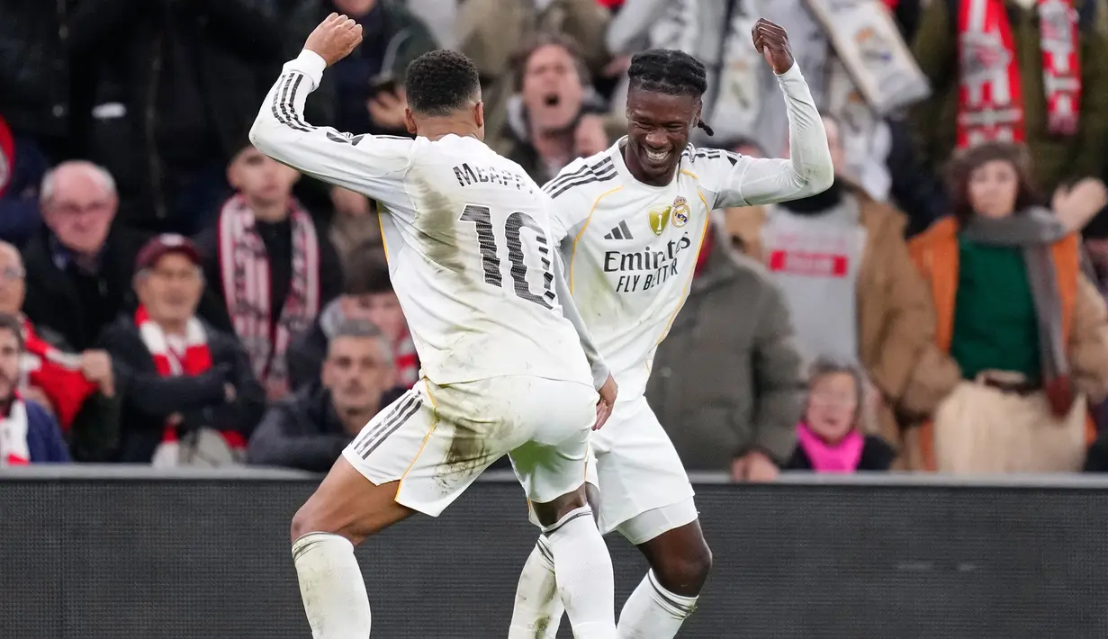 Pemain Real Madrid, Kylian Mbappe (kiri) berjoget dengan Eduardo Camavinga setelah mencetak gol ke gawang Athletic Bilbao dalam laga lanjutan Liga Spanyol 2025/2026 di Stadion San Mames, Bilbao, Spanyol, Rabu (03/12/2025). (AP Photo/Jose Breton)