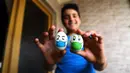 Seorang anak menunjukkan telur yang dilukis dalam rangka merayakan Festival Sham el-Nessim dari rumah di tengah pandemi virus corona COVID-19 di Kairo, Mesir, Senin (20/4/2020). Sham el-Nessim adalah festival tradisional Mesir yang menandai awal musim semi. (Xinhua/Ahmed Gomaa)