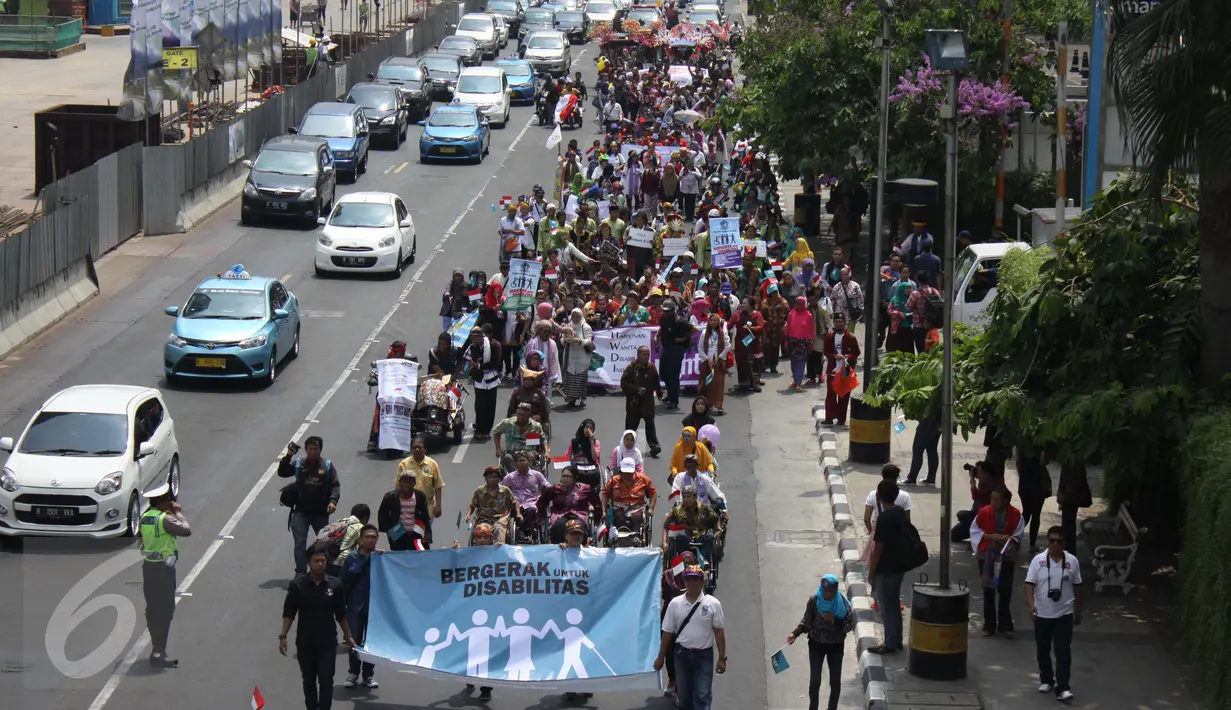 Sejumlah penyandang disabilitas membawa poster saat Karnaval Budaya Disabilitas di kawasan Bundaran HI, Jakarta, Selasa (18/08/2015). Acara ini dibuat untuk membangun Indonesia yang ramah kepada penyandang disabilitas. (Liputan6.com/Gempur M Surya)  