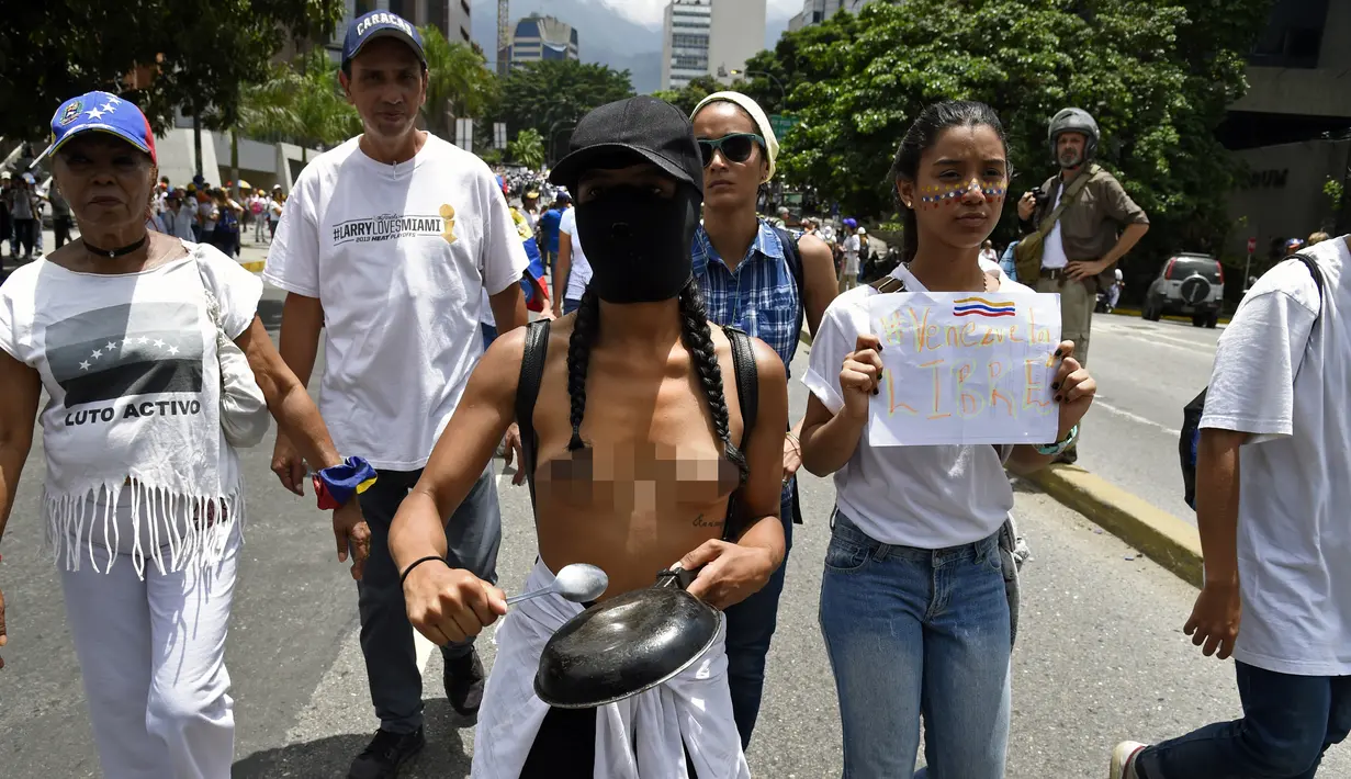 Aksi seorang wanita bertelanjang dada saat berunjuk rasa menentang Presiden Venezuela Nicolas Maduro di Caracas, Sabtu (6/5). Secara keseluruhan, aksi protes massal menentang Maduro telah berlangsung lebih dari satu bulan. (AFP PHOTO / FEDERICO PARRA)