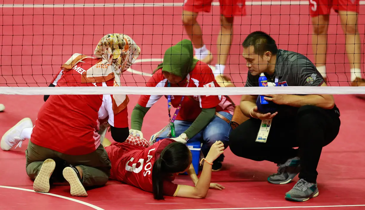 Pemain sepak takraw Laos, Koy Xayavong mendapat perawatan medis karena cedera saat melawan tim Korea Selatan pada penyisihan quadrant putri sepak takraw Asian Games 2018, Palembang, Sumatera Selatan, Rabu (29/8). (ANTARA FOTO/INASGOC/Ferdy Siregar/nz/180)