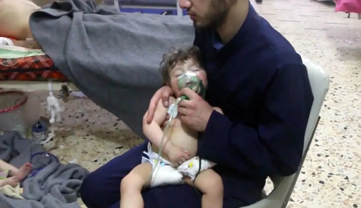 Petugas medis memberikan oksigen kepada bayi setelah diduga terkena serangan senjata kimia di Kota Douma, dekat Damaskus, Suriah, Minggu (8/4). PBB menyatakan pemerintah Suriah harus bertanggung jawab. (Syrian Civil Defense White Helmets via AP)