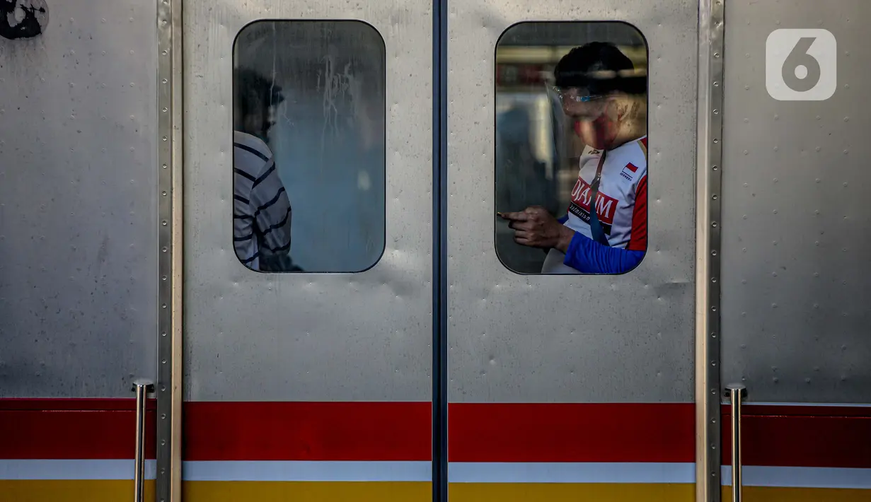 Penumpang bermain ponsel di dalam KRL di Stasiun Tanah Abang, Jakarta, Sabtu (19/9/2020). Kereta-kereta terakhir meninggalkan wilayah DKI Jakarta sekitar pukul 19:00 WIB. Kapasitas pengguna tetap dibatasi hingga 74 orang per kereta. (Liputan6.com/Faizal Fanani)