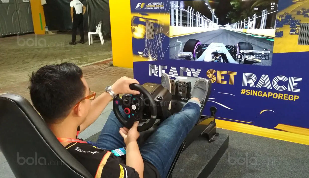 Seorang pengunjung sedang bermain game di pit stop challenge pada ajang F1 GP Singapura, (17/9/2017). Kegiatan ini untuk menarik warga mengenal tentang F1. (Bola.com/Wirawan Kusuma)