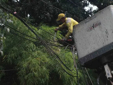 Petugas Dinas Bina Marga DKI Jakarta menata instalasi kabel yang semrawut di Jalan Yusuf Adiwinata, Menteng, Jakarta Pusat, Jumat (11/8/2023). (merdeka.com/Imam Buhori)