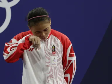 Lifter Lisa Setiawati menangis saat naik podium usai mendapatkan medali perak SEA Games 2019 cabang angkat besi nomor 45 kg di Stadion Rizal Memorial, Manila, Minggu (1/12). Dirinya meraih perak dengan total angkatan 169 kg. (Bola.com/M Iqbal Ichsan)