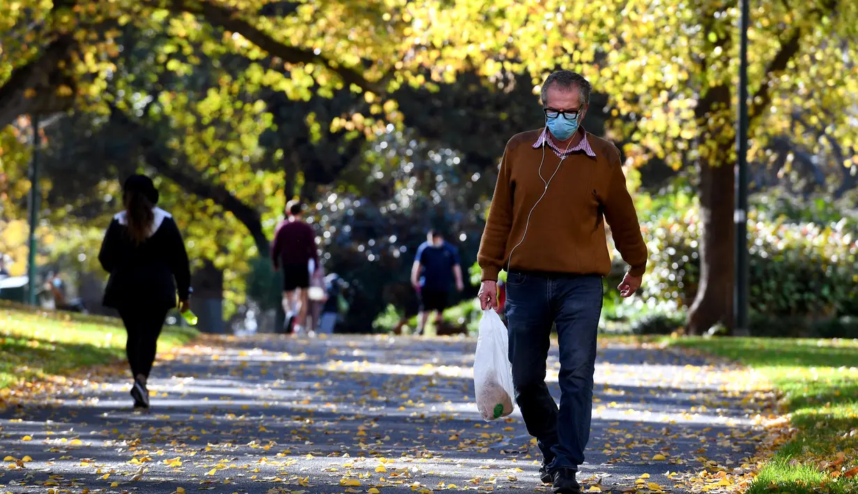 Seorang pria berjalan di taman kota ketika penguncian coronavirus di Melbourne, Australia (3/6/2021). Pihak berwenang mengumumkan Lockdown di Melbourne diperpanjang tujuh hari lagi ketika negara itu berusaha untuk membasmi sekelompok kasus Covid-19 di Melbourne. (AFP Photo/William West)